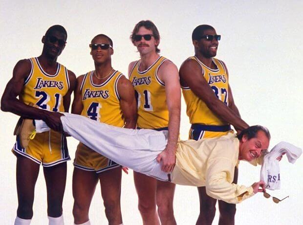 Tres jugadores de los Lakers y Magic Johnson sujetando al entrenador de forma cómica
